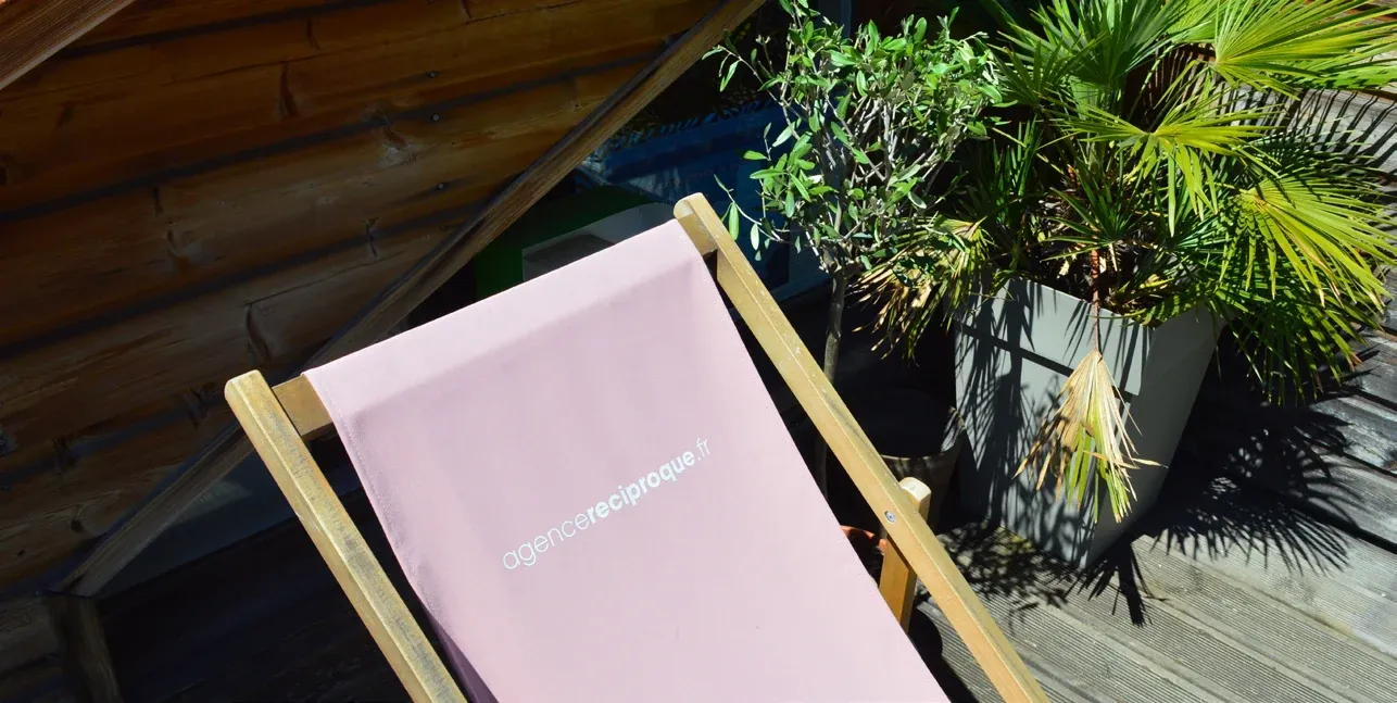 Un carnet posé sur un bureau en bois au milieu des plantes